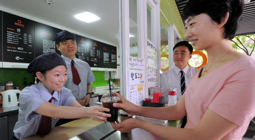 Staff at Gwanghwamun’s Haenuri Cafe serve customers. (The Korea Herald)