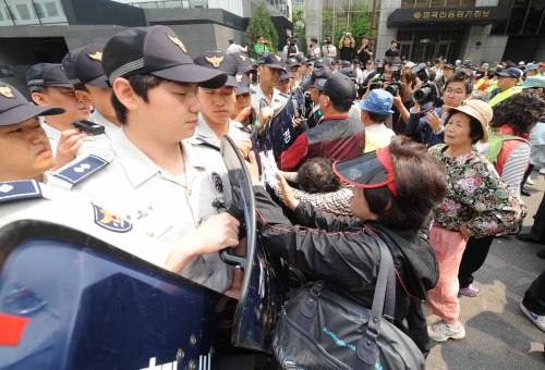 A group of people who lost part of their savings in Busan Mutual Savings Bank on Tuesday rally against politicians’ move to scrap the central investigation unit of the Supreme Prosecutors’ Office near the main gate of the National Assembly. (Lee Sang-sub/The Korea Herald)