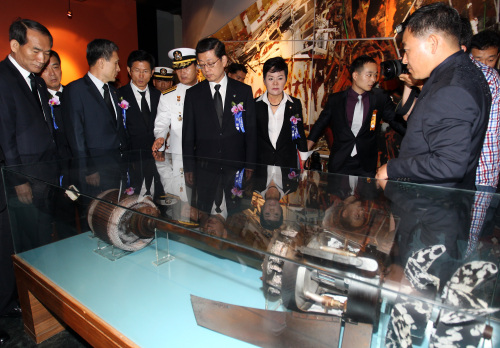 Prime Minister Kim Hwang-sik (third from right) and other participants in a ceremony to mark the anniversary of a 2002 naval skirmish look at a North Korean torpedo part ― used to attack the warship Cheonan last year ― on display in Pyeongtaek, Gyeonggi Province, Wednesday. (Yonhap News)