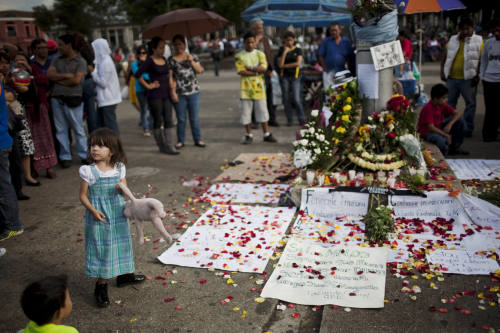 Nicoleta, 3, stands next to an altar made by mourners after the murder of Argentine artist Facundo Cabral in Guatemala City, Saturday. (AP-Yonhap News)
