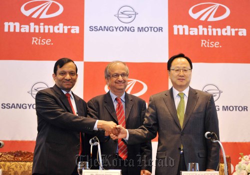 Ssangyong Motor CEO Lee Yoo-il (right) poses with Mahindra and Mahindra CFO Bharat Doshi (center) and the Indian firm’s president for automotive and farm sector Pawan Goenka at a press conference in Seoul last March. (Ssangyong Motor Co.)