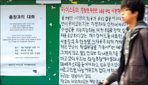 A student walks past a poster protesting reforms at KAIST earlier this year. An English-only lecture policy was among those sparking controversy. (Yonhap News)