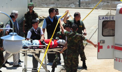 Medics load a dummy of a Marine corporal onto a gurney in a reenactment of the shootingrampage that took the lives of four marines and injured another on Ganghwa Island, Tuesday. (Yonhap News)
