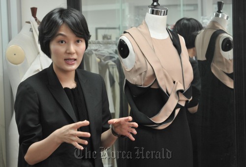 Leyii creative director Lee Seung-hee with one of her 2011 S/S collections. (Chung Hee-cho/The Korea Herald)