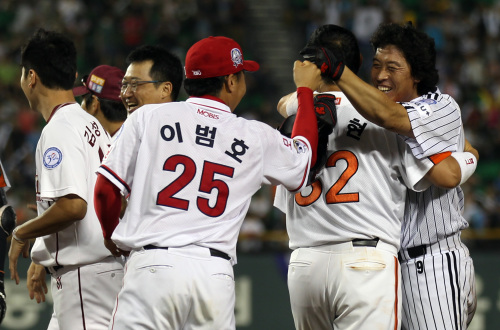 Lee Byung-kyu (right) celebrates with his teammates after hitting a single in the 10th inning on Saturday at Jamsil Stadium. (Yonhap News)