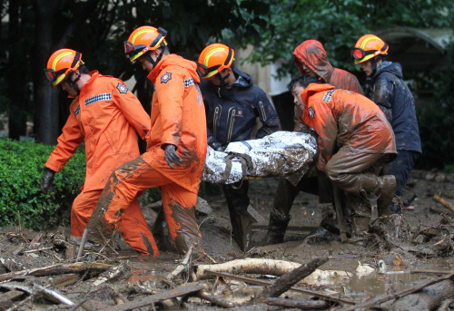 Rescue crew evacuate a resident on a stretcher from an area hit by a landslide in Chuncheon. (Yonhap News)