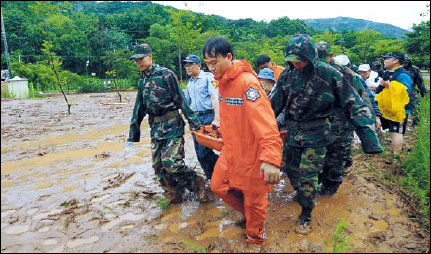 Rescue crew evacuate a resident on a stretcher from an area hit by a landslide in Chuncheon, Gangwon Province, Wednesday. (Park Hyun-koo/The Korea Herald)