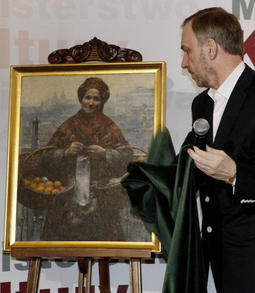 Poland’s Culture Minister Bogdan Zdrojewski shows the 19th century painting “Jewish Woman Selling Oranges” by Polish painter Aleksander Gierymski to reporters in Warsaw, Poland on Wednesday. (AP-Yonhap News)