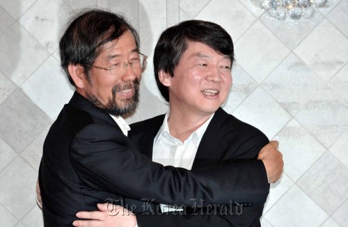 Prof. Ahn Cheol-soo (right) and civic activist Park Won-soon embrace after Ahn’s announcement last month that he will support Park in Seoul mayoral by-election. (Chung Hee-cho/The Korea Herald)
