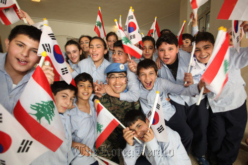 Army Chaplain Capt. Kim Soon-kyu of the Dongmyeong unit in Lebanon poses for a photo with local students on his visit to a school in March for an “Inviting Korea” event to promote Korean culture. (JCS)