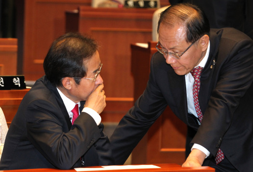 Grand National Party chairman Hong Joon-pyo (left) speaks with floor leader Hwang Woo-yea prior to a general meeting of GNP lawmakers at the National Assembly in Yeouido, Seoul, on Friday. (Yonhap News)