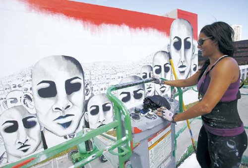 Wallscape artist Subi Roberto surveys her mural “We Are Lightwalkers” Tuesday in downtown Miami. (AP-Yonhap News)