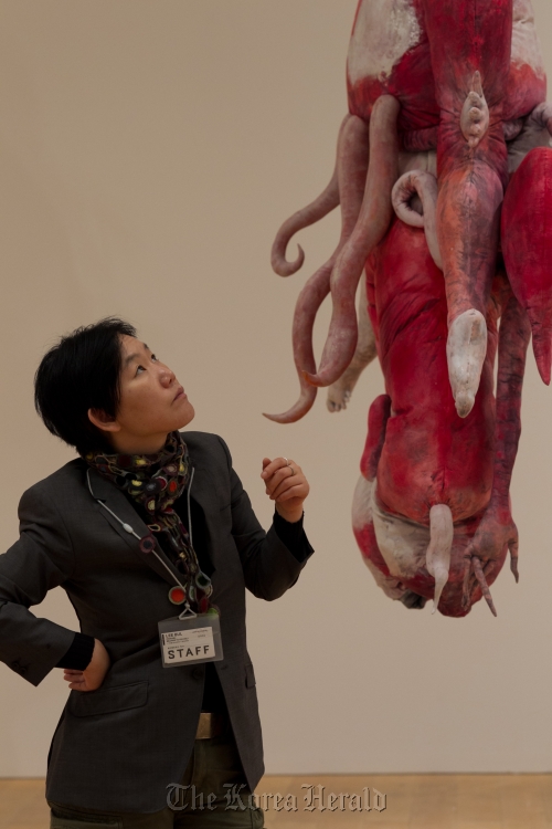Artist Lee Bul looks up at one of her installation pieces, a recreation of the monster costume she wore for her performances, before the opening of her solo exhibit at Mori Art Museum in Tokyo. (Mikuriya Shinichiro/Mori Art Museum)