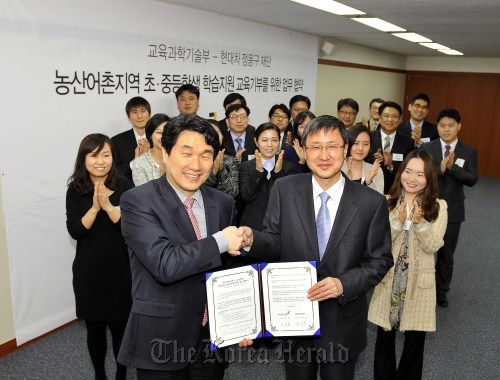 Education Minister Lee Ju-ho (left) and Chung Mong-koo Foundation chairman Yoo Young-hak shake hands after signing an agreement to foster education donations and support students living in the country’s rural areas at a ceremony on Thursday in Seoul. (Hyundai Motor Group)