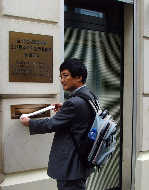 Kim Tae-jin, a human rights activist in Seoul who defected from North Korea, puts a letter into the mailbox at the North Korean representative office in Paris on Sunday, urging the dismantling of prison camps. (Yonhap News)