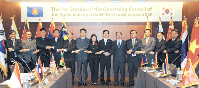 Korea Forest Service Minister Lee Don-koo (sixth from right) joins hands with participants after the 1st Session of the Governing Council of the Agreement on ASEAN-Korea Forest Cooperation at Hotel Shilla in central Seoul on Tuesday. (KFS)