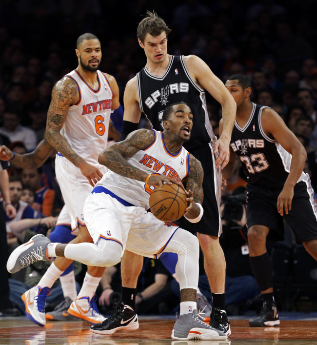 New York Knicks guard J. R. Smith (8) looks to pass against San Antonio Spurs forward Tiago Splitter (rear), as Knicks center Tyson Chandler (6) watches in the first half of their NBA basketball game at Madison Square Garden in New York on Thursday. The Knicks won 100-83. (AP-Yonhap News)