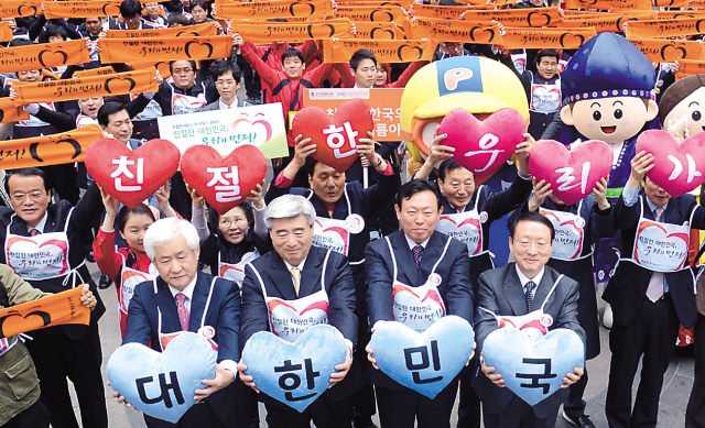 Shin Dong-bin (second from right, front row), chairman of Visit Korea Committee, Nam Sang-man (right, front row), chairman of Korea Tourism Association, and about 300 other tourismrelated workers launch a campaign to be kind to foreign tourists in front of Myeongdong Theater in Seoul on Tuesday. Many Japanese and Chinese travelers are expected to visit Korea on long holidays from late April. (Ahn Hoon/The Korea Herald)