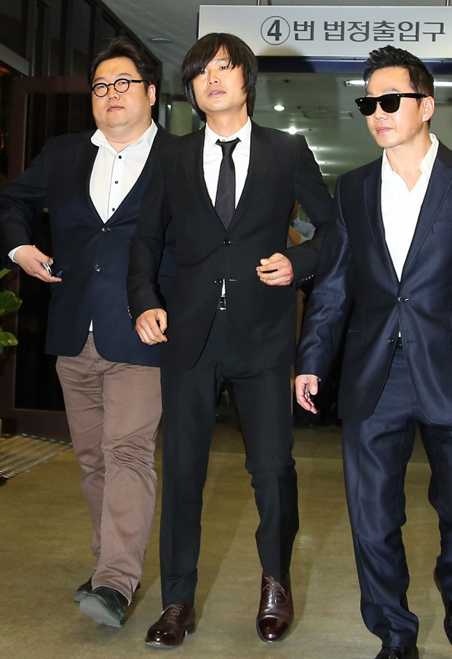 Joo Jin-woo (center), a reporter for the monthly news magazine Sisa IN, appears at the Seoul Central District Court to attend a hearing on charges that he spread false information to influence December’s presidential election. (Yonhap News)