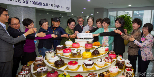 Adoptees, lawmakers and others involved in the movement to support the rights of unwed mothers and Korean adoptees take part in a cake-cutting ceremony at the Single Moms’ Day International Conference on May 10 at the National Assembly. (Jes Eriksen)