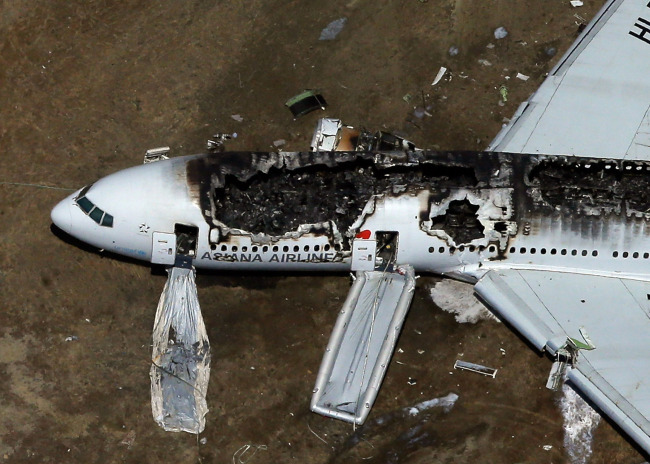 A Boeing 777 airplane lies burned on the runway after it crash landed at San Francisco International Airport July 6 in San Francisco, California. An Asiana Airlines passenger aircraft coming from Seoul, South Korea crashed while landing. There has been at least two casualties reported. (AFP)