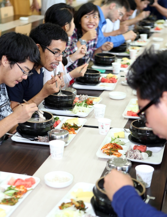 Foreign exchange students of Tongmyong University in Busan eat samgyetang as part of “Global Samgyetang Day” to introduce foreigners to Korean food. (Yonhap News)