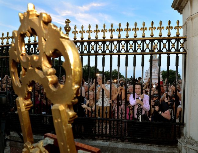 The large waiting crowds cheers as they read the news on an easel in the forecourt of Buckingham Palace, to announce the birth of a baby boy, at 4.24pm to the Duke and Duchess of Cambridge at St Mary's Hospital in west London, Monday July 22, 2013. The notification was set up on an easel facing the gates for public view. The child is now third in line to the British throne. (AP-Yonhap News)