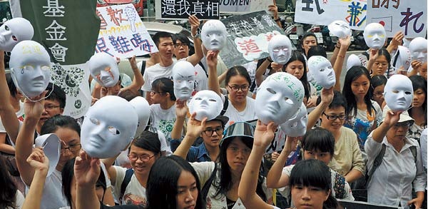 Supporters display masks as they demand an apology from Japan over the comfort women issue during a demonstration in front the Japan Interchange Association in Taipei on Wednesday. (AFP-Yonhap News)
