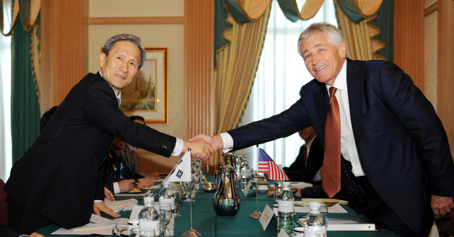South Korean Defense Minister Kim Kwan-jin shakes hands with U.S. Defense Secretary Chuck Hagel during their bilateral meeting on the sidelines of the ASEAN Defense Ministers Meeting-Plus in Bandar Seri Begawan, Brunei, Wednesday. (Defense Ministry)