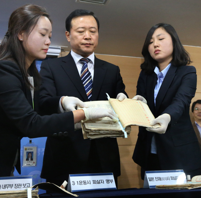 National Archives President Park Kyung-kook (center) holds up the list of Koreans killed after the 1919 independence movement and the 1923 Kanto earthquake at the government complex in Seoul on Tuesday. (Yonhap News)