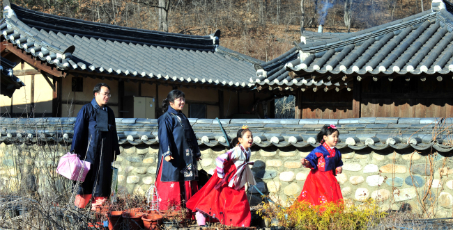 Family reunions are the most important part of Lunar New Year traditions. A family, donned in hanbok gowns, heads for their hometown in Chungju, North Chungcheong Province, to spend the holidays with their relatives.(Kim Myung-sub/The Korea Herald)