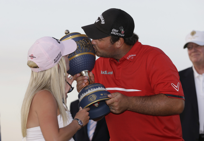Patrick Reed and his wife kiss the winner’s trophy on Sunday. (AP-Yonhap)