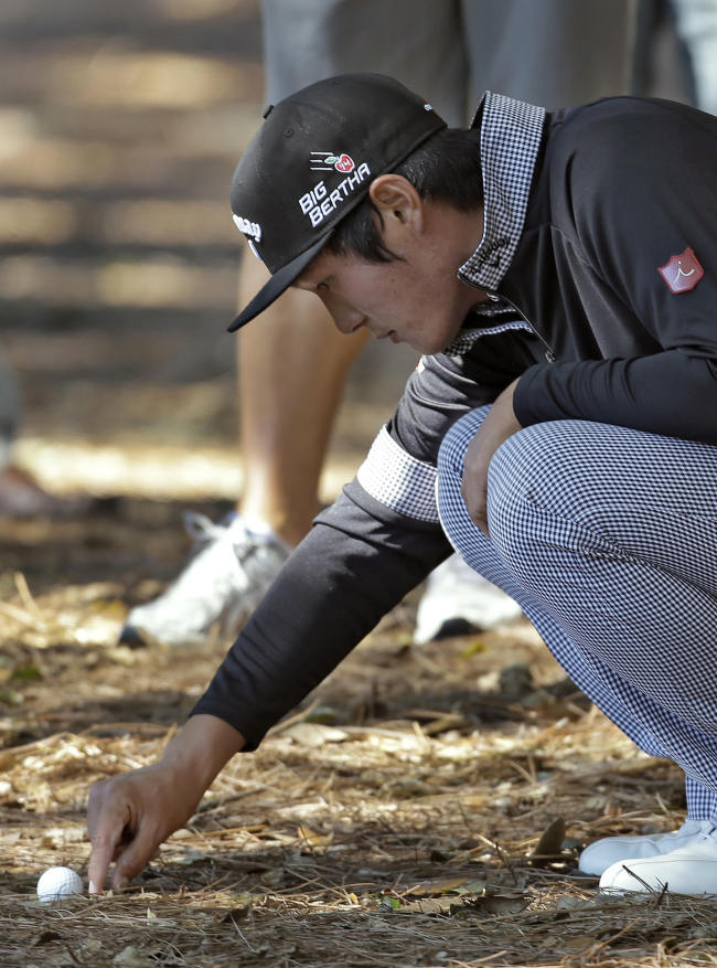 Danny Lee clears debris around his golf ball on Thursday. (AP-Yonhap)