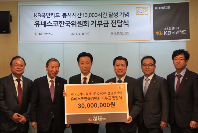KB Kookmin Card CEO Kim Duk-soo (third from left) delivers a 30 million won ($29,000) donation to Min Dong-seok, secretary-general of the Korean National Commission for UNESCO. (KB Kookmin Card)