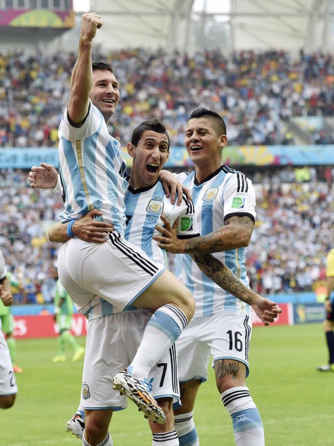 Argentina`s Lionel Messi, left, is carried by his teammates Argentina`s Angel di Maria (7) and Marcos Rojo (16) after scoring his side`s first goal during the group F World Cup soccer match against Nigeria at the Estadio Beira-Rio in Porto Alegre, Brazil, Wednesday. (AP)