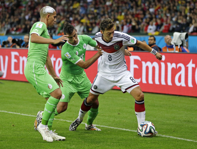 Germany's Mesut Ozil, right, holds off Algeria's Saphir Taider and Sofiane Feghouli during the World Cup round of 16 soccer match between Germany and Algeria at the Estadio Beira-Rio in Porto Alegre, Brazil, Monday, June 30, 2014. (AP-Yonhap)