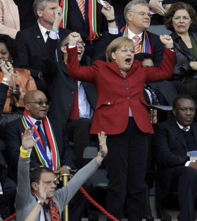 This 2010 file photo shows German Chancellor Angela Merkel celebrating after a goal at the World Cup in South Africa. (AP-Yonhap)