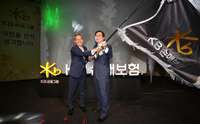 KB KICKS OFF INSURANCE BIZ -- KB Financial Group chairman Yoon Jong-kyoo (left) and KB Insurance president Kim Byung-heon celebrate the launch of KB‘s new insurance company Wednesday. The banking group took over LIG Insurance in March this year, in an aim to expand its non-banking business. KB Financial Group