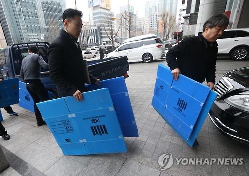 Officials carry out boxes of confiscated items Tuesday from the office of an aide to the former president of the Korea Railroad Corp. in Yeongdeungpo, Seoul. (Yonhap)