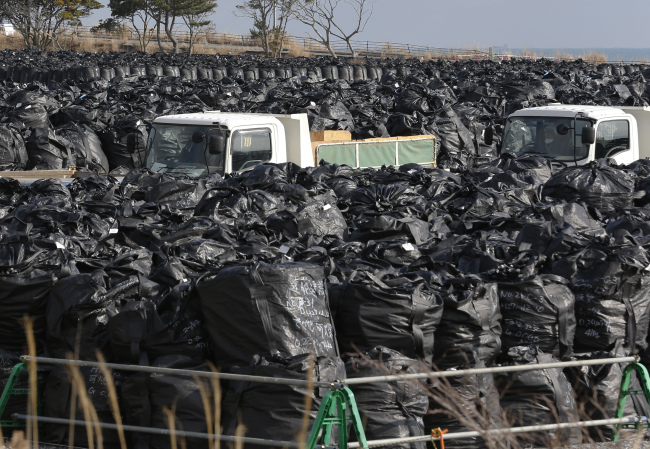In this Feb. 24, 2016 photo, trash bags filled up with collected radioactive soils, plants and other trash are packed at a temporary waste storage site in Tomioka, Fukushima prefecture, northeastern Japan. (AP-Yonhap)