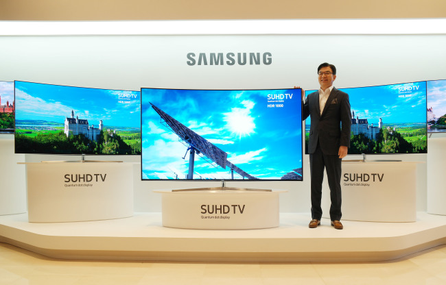 Samsung Electronics president and TV chief Kim Hyun-seok poses with the company’s latest quantum dot TVs at a launch event in Seoul on Tuesday. (Samsung Electronics)