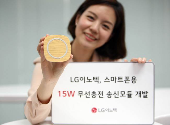 A model poses with a wireless smartphone charger pad installed with LG Innotek’s 15-watt power-receiving modules. (LG Innotek)