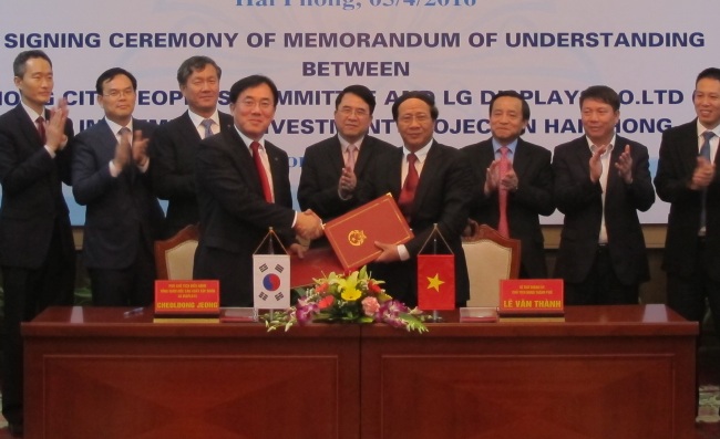 Jeong Cheol-dong (fourth from left), LG Display chief production officer, and Le Van Thanh (fourth from right), chief secretary of the Hai Phong city government, pose for photos at a MOU signing ceremony held in the city on Tuesday. (LG Display)