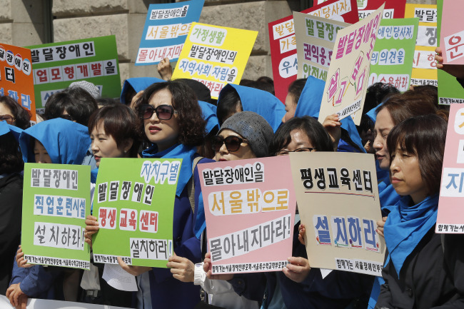 Members of civic group Korean Parents’ Network for People with Disabilities urge the city government to draw up support measures for children with developmental disabilities at Seoul City Hall, Monday. Yonhap