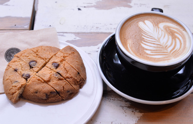 Hayley`s Cafe`s massive dark chocolate chip cookie (left) and an Australian-style flat white (Lee Sang-sub/The Korea Herald)