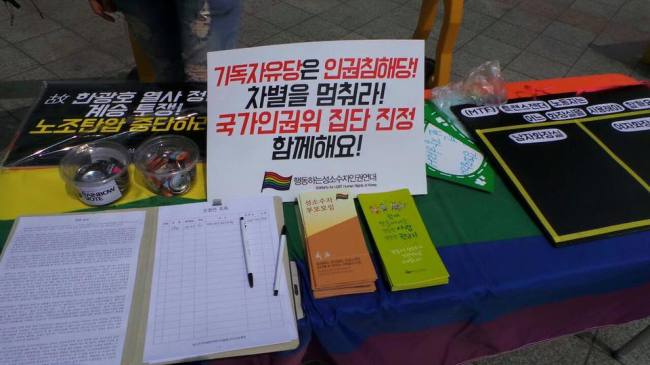 There are a flyer reading “Christian Libertarian Party is Human Rights Violation Party! Stop discrimination! Please join us for filing a petition with the National Human Rights Commission of Korea!” and a piece of paper to collect signatures on a makeshift table during a May Day rally held in central Seoul, Sunday. (Solidarity for LGBT Human Rights of Korea)