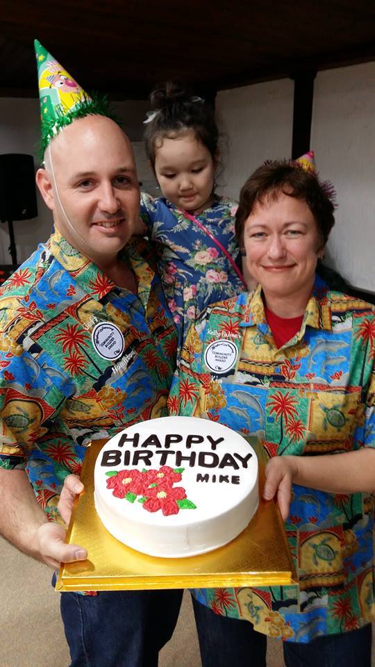 Jeff Hamilton and Kelly Palmer Kim pose with their shirts and a cake celebrating Michael Simning’s birthday at the award ceremony for the Michael Simning Community Builder Award at the Gwangju International Center on Saturday. (Nancy Harcar)