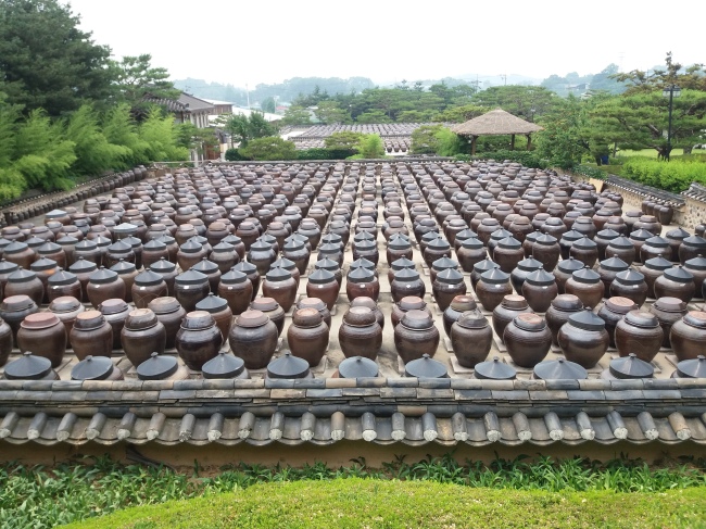Porous onggi clay pots are filled with jang fermenting in the sun. (Christine Cho)