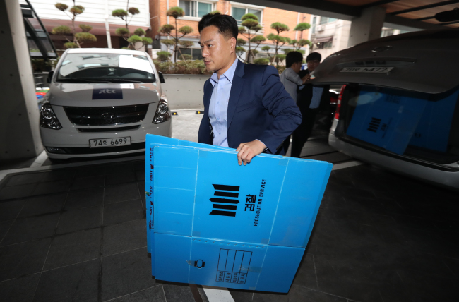 An investigator takes paper boxes into the K-Sports Foundation building in Gangnam, southern Seoul, Wednesday, as the prosecution begins a search of the foundation’s office as part of an ongoing investigation. (Yonhap)
