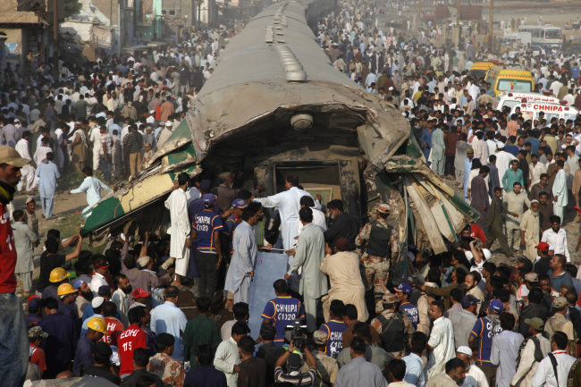 Pakistani volunteer rescuers work at the site of a train accident in Karachi, Pakistan, Thursday. (AP)